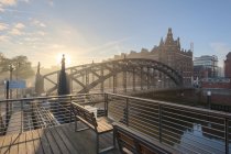 Germany, Hamburg, Speicherstadt at sunrise and bridge over water — Stock Photo