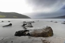 UK, Scozia, Veduta del lago con pietre in acqua contro le colline durante il giorno — Foto stock