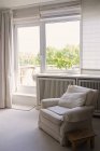 Wohnzimmer mit Sessel, Fenster und Tür zur Unterkunft — Stockfoto