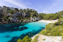 Espanha, Ilhas Baleares, Menorca, Macarella, Cala Macarelleta, Praia com penhasco na costa — Fotografia de Stock