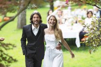 Sposa e sposo a piedi su una festa in giardino — Foto stock