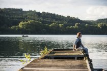 Allemagne, Rhénanie-Palatinat, Lac Laach, Homme assis sur une promenade en bois — Photo de stock