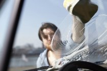 Mann wäscht Autoscheibe — Stockfoto