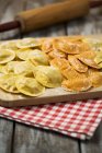 Variety of ravioli filled with tomato, ham and mushrooms on chopping board — Stock Photo