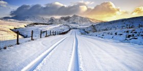 Großbritannien, Schottland, Blick auf Reifenspur und Schneeberge — Stockfoto