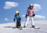 Switzerland, Boy and girl skiing in snow — Stock Photo