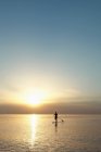 Silhouette of man rowing on paddle board — Stock Photo