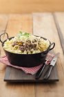 Minced meat with pasta in pan on chopping board — Stock Photo