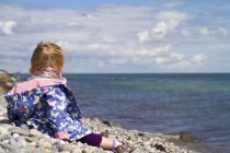 Девушка сидит на пляже — стоковое фото