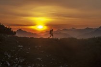 Mann wandert bei Sonnenaufgang durch Niedertauerngebirge im Salzburgerland, Österreich — Stockfoto