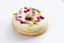 Doughnut with icing and colorful sprinkles — Stock Photo
