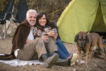 Glückliches Seniorenpaar mit Wein und Hund im Zelt — Stockfoto