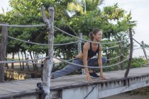 Indonésie, Bali, femme qui s'étire sur le pont — Photo de stock