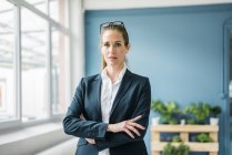 Geschäftsfrau steht zu Hause mit verschränkten Armen — Stockfoto