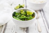 Green thai curry with broccoli, pak choi, snow peas, baby spinach, lime and rice — Stock Photo