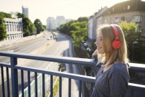 Портрет усміхненої молодої жінки, що слухає музику з навушниками — стокове фото