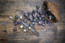 Фіолетовий Брюссельська капуста розкидані по сільському дерев'яному столі з кошиком і іржавий ножем — стокове фото