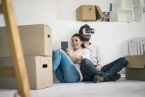 Пара сидячи в новому будинку з чоловіком носити окуляри VR — стокове фото