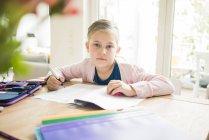 Retrato de menina fazendo lição de casa na mesa — Fotografia de Stock