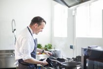 Cocinar preparando comida en la cocina - foto de stock