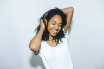 Портрет щасливої молодої жінки, яка слухає музику навушниками. — стокове фото