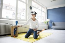 Donna vitale a casa indossando occhiali VR mentre pulisci il pavimento — Foto stock