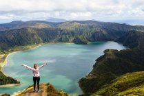 Azores, sao miguel, Frau mit erhobenen Armen auf der Spitze der Lagune do fogo — Stockfoto