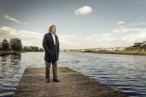 Senior homem de pé no molhe no lago — Fotografia de Stock