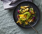 Filled and gratinated avocado with egg and artichoke — Stock Photo