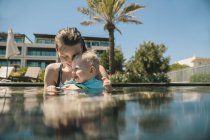 Happy mother and baby son in swimming pool — Stock Photo