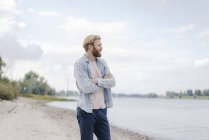 Schöner Mann, der am Flussufer steht und die Hände gekreuzt hält — Stockfoto
