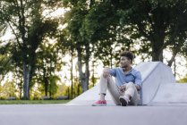 Retrato de hombre afroamericano relajado sentado en skatepark - foto de stock