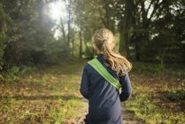 Visão traseira de menina em uma floresta — Fotografia de Stock