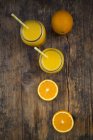 Freshly squeezed orange juice in jars with straws — Stock Photo