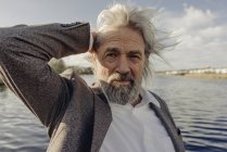 Portrait of serious senior man at lake — Stock Photo
