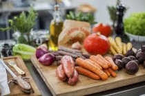 Different fresh vegetables on chopping board — Stock Photo