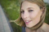 Porträt einer lächelnden jungen Frau, die in die Kamera blickt — Stockfoto