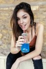 Ritratto di una donna bruna sorridente che beve limonata blu — Foto stock
