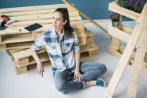 Beautiful woman planning to refurbish her home with pallets — Stock Photo