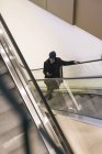 Італія, Мілан, афроамериканець людина з смартфоном на ескалаторі — стокове фото
