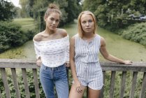 Портрет двох молодих жінок, що стоять на мосту — стокове фото