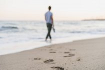 Marcas de pé de homem passeando à beira-mar, close-up — Fotografia de Stock