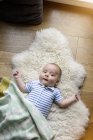 Ritratto di neonato sdraiato su agnello — Foto stock