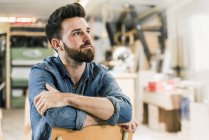 Homme assis sur la chaise dans l'atelier — Photo de stock