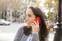 Smiling woman on cell phone in the city — Stock Photo