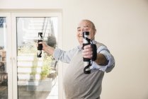 Портрет улыбающегося пожилого мужчины, делающего упражнения на руке — стоковое фото
