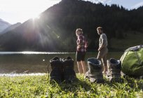 Austria, Tyrol, hiking shoes and couple refreshing in mountain lake — Stock Photo