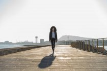 Spagna, Barcellona, donna che indossa giacca con cappuccio e cammina sul lungomare — Foto stock