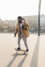 Giovane uomo afroamericano su skateboard sul campo — Foto stock