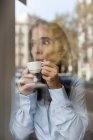 Бізнес-леді п'є еспресо за віконною панеллю — стокове фото